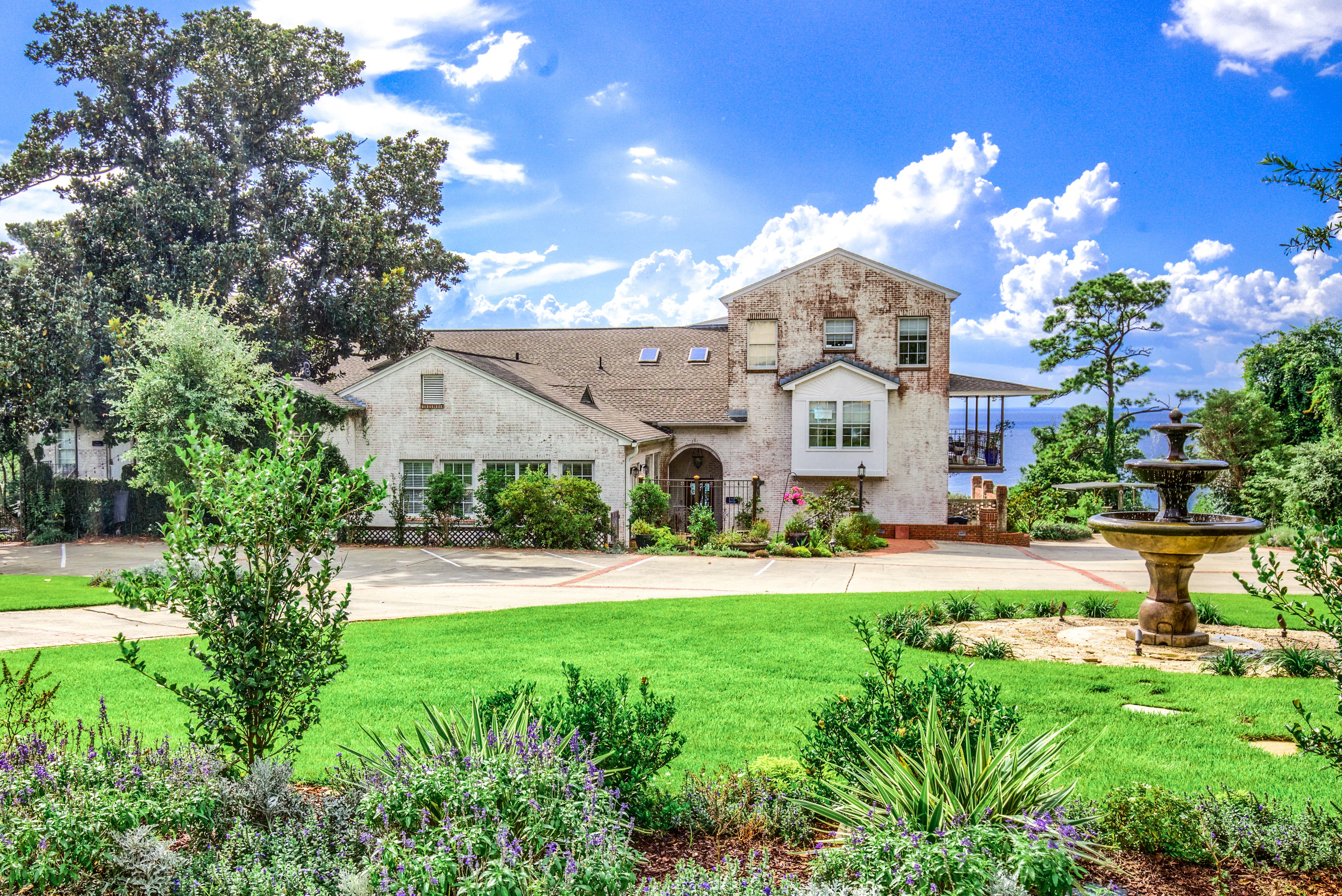 Street view of Jubilee Suites with beautifully manicured lawn and fountain in foreground