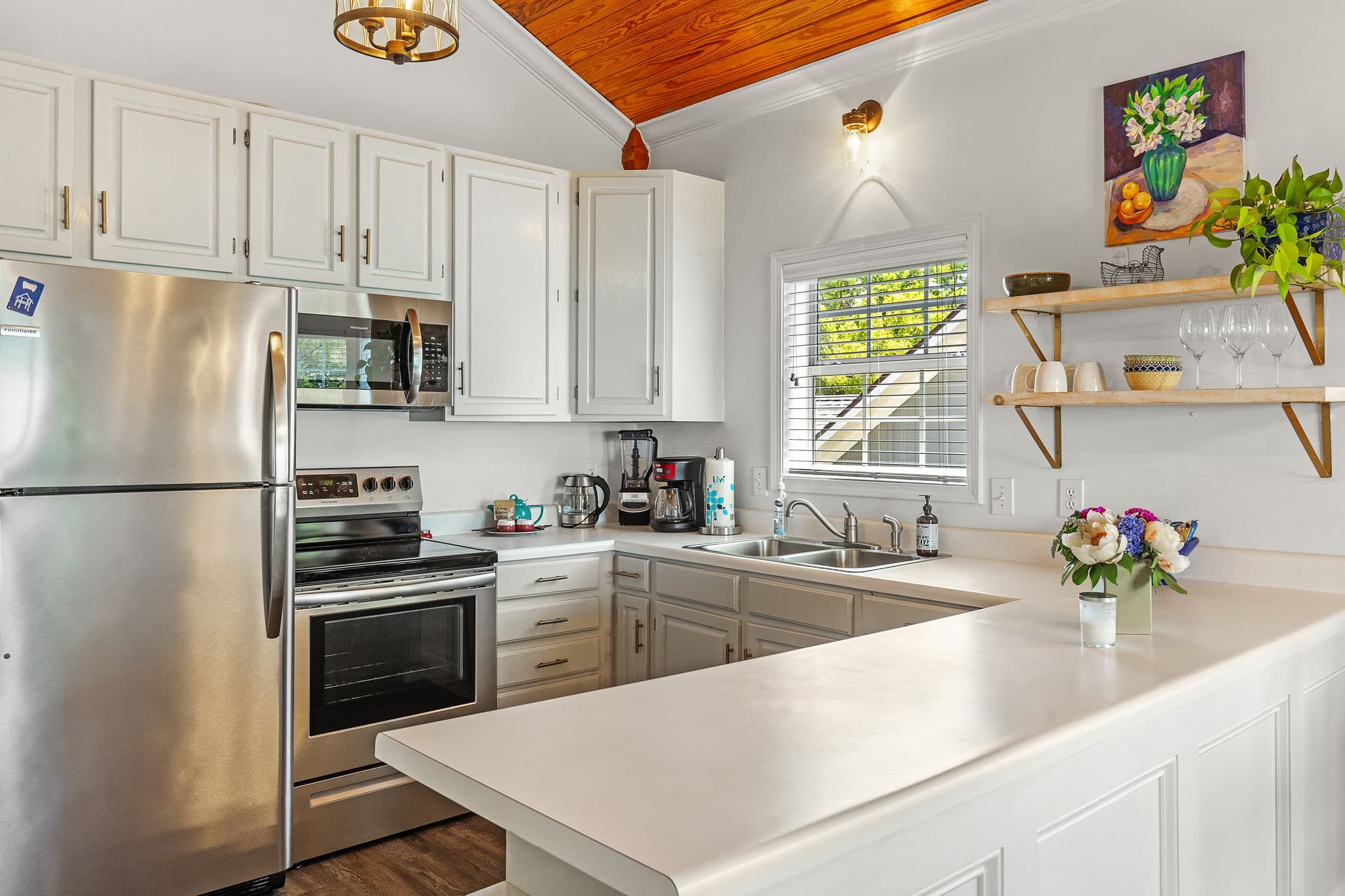 Full kitchen with white cabinetry, stainless steel fridge, stove, and microwave