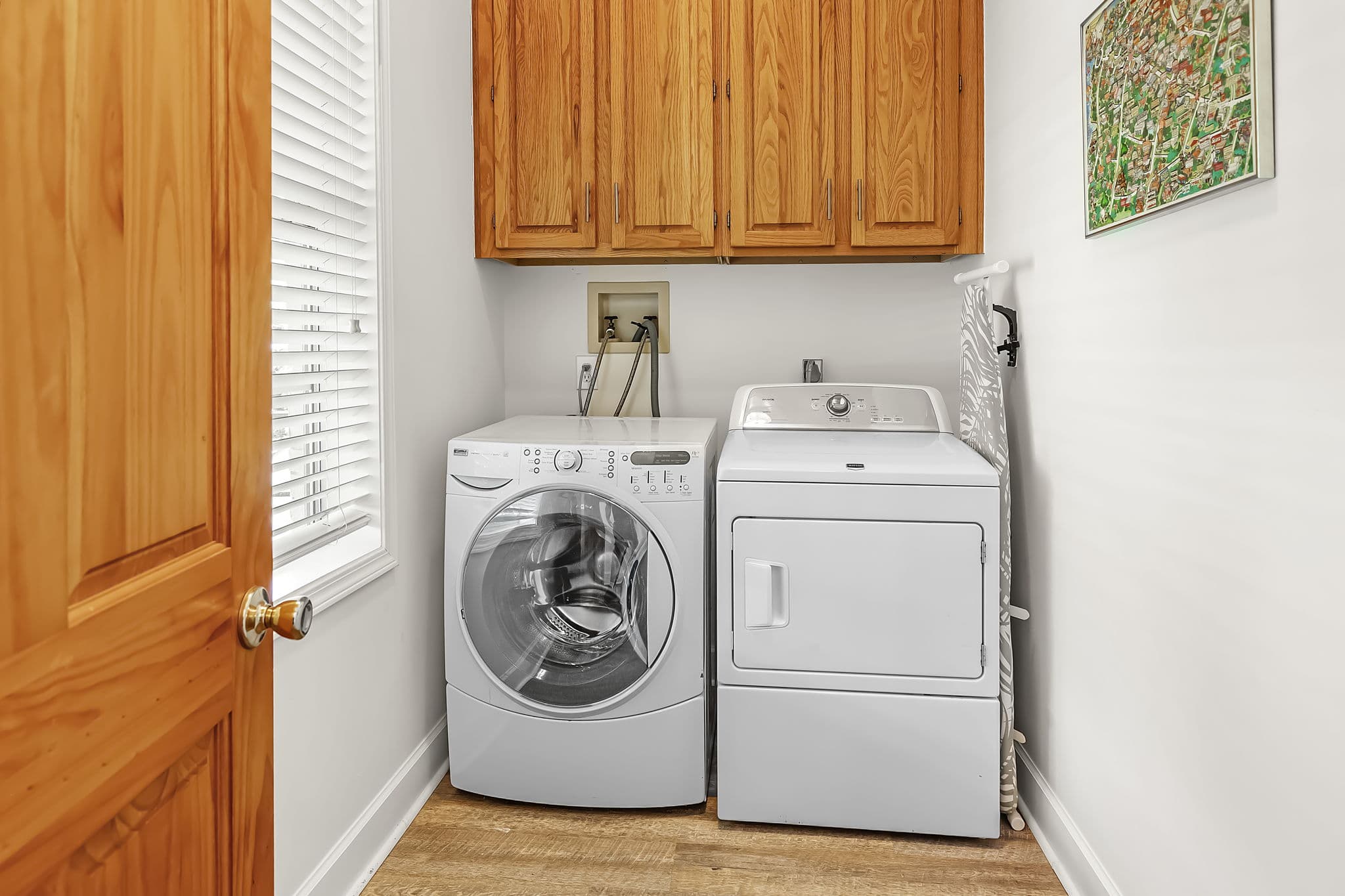 Laundry Room with washing machine and clothes dryer and wooden cabinetry above