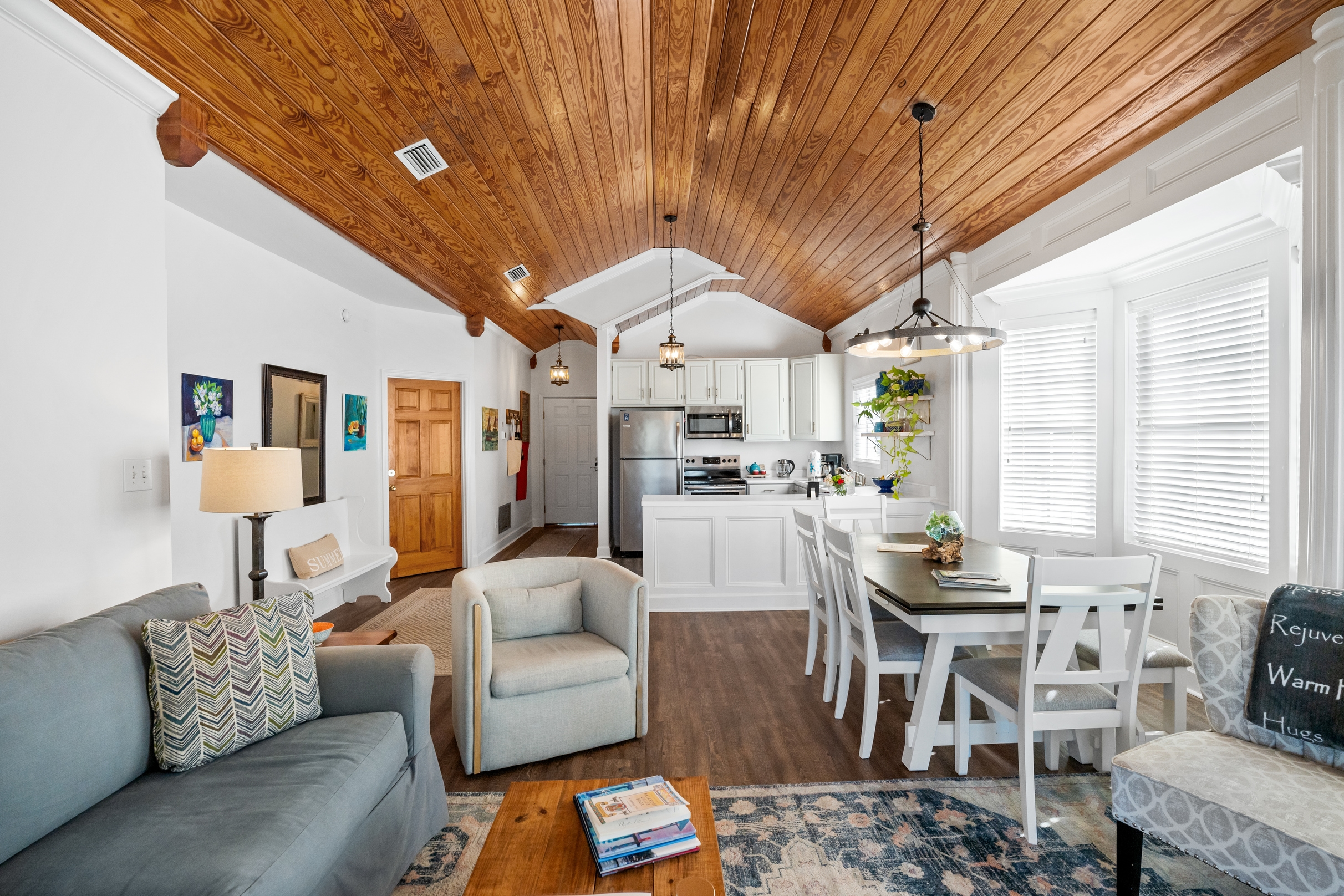Main living area with plush couch, matching armchair, and wood-topped coffee table positioned on area rug