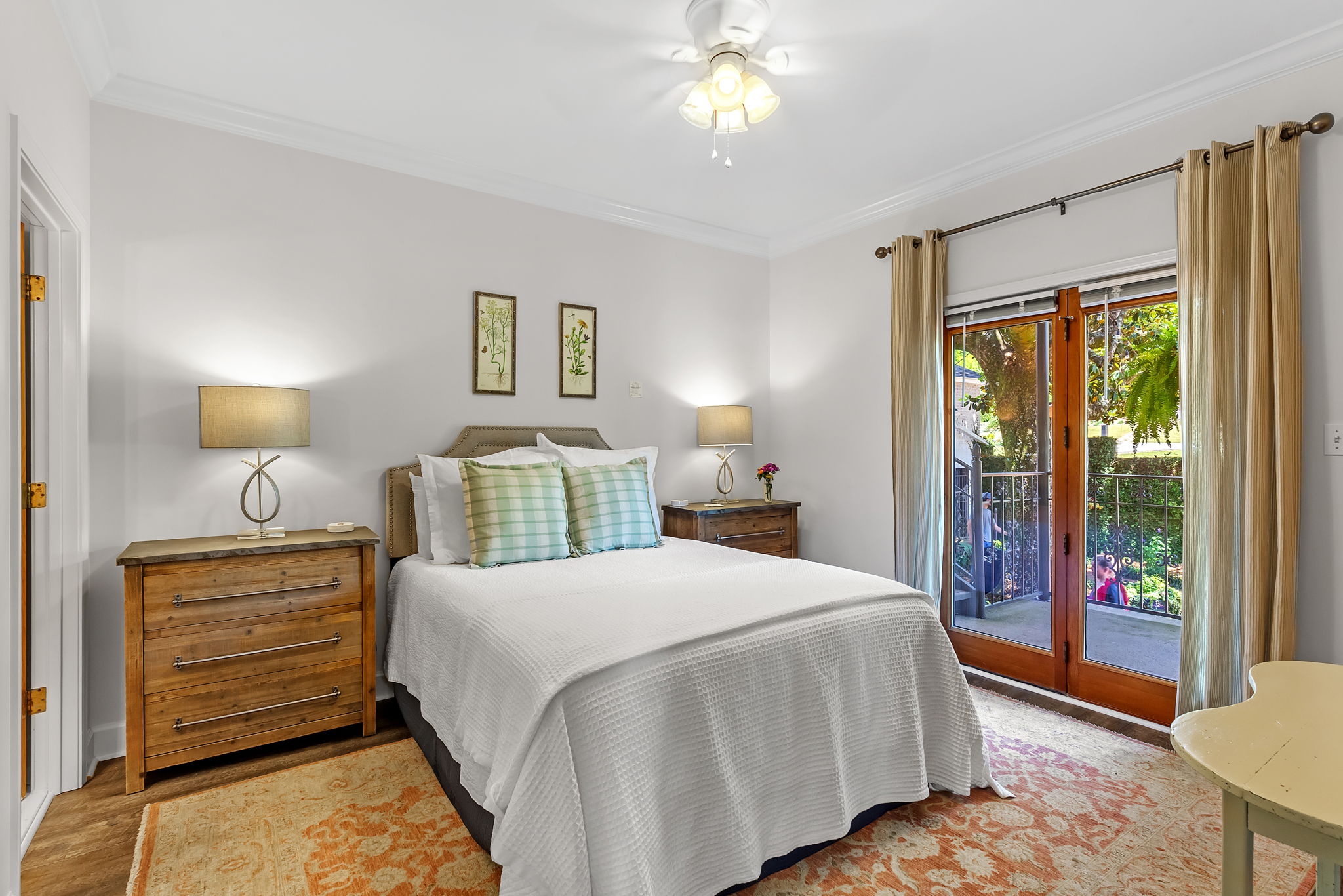 Second Bedroom with king bed flanked by wooden nightstands topped by table lamps, sliding glass doors leading outside