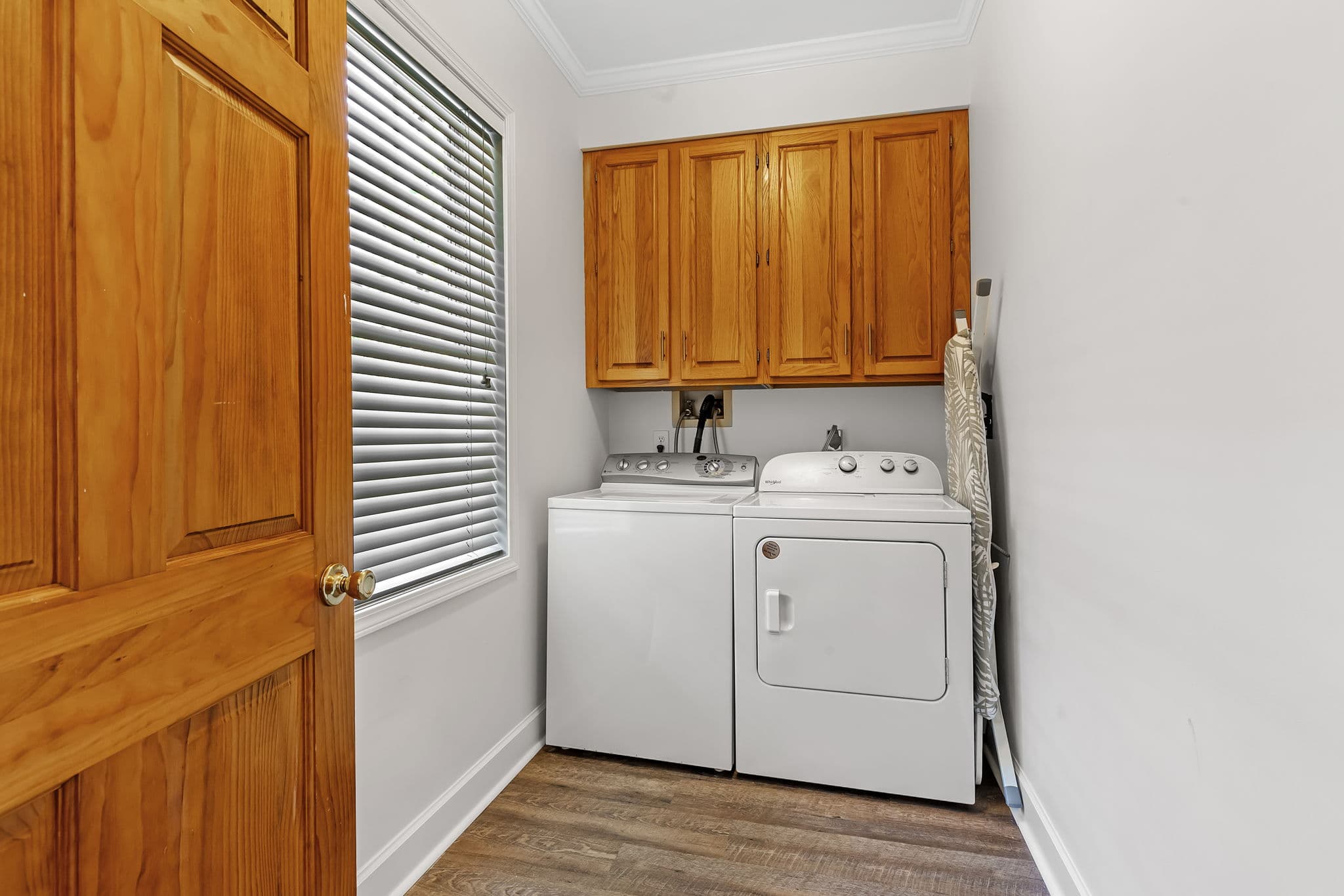 Laundry Room with washing machine and clothes dryer and wooden cabinetry above