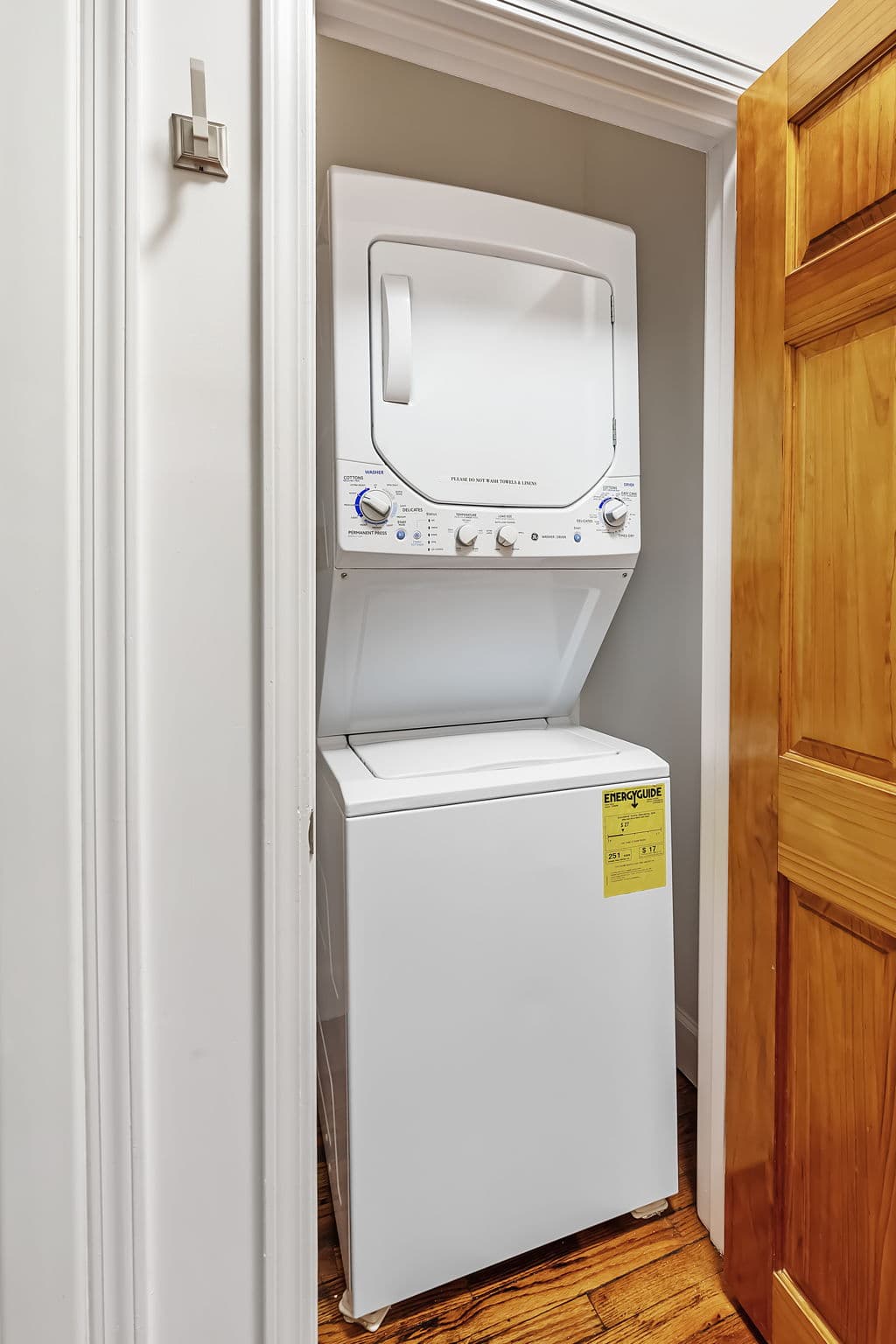 Private laundry closet with a stacked washer and dryer.