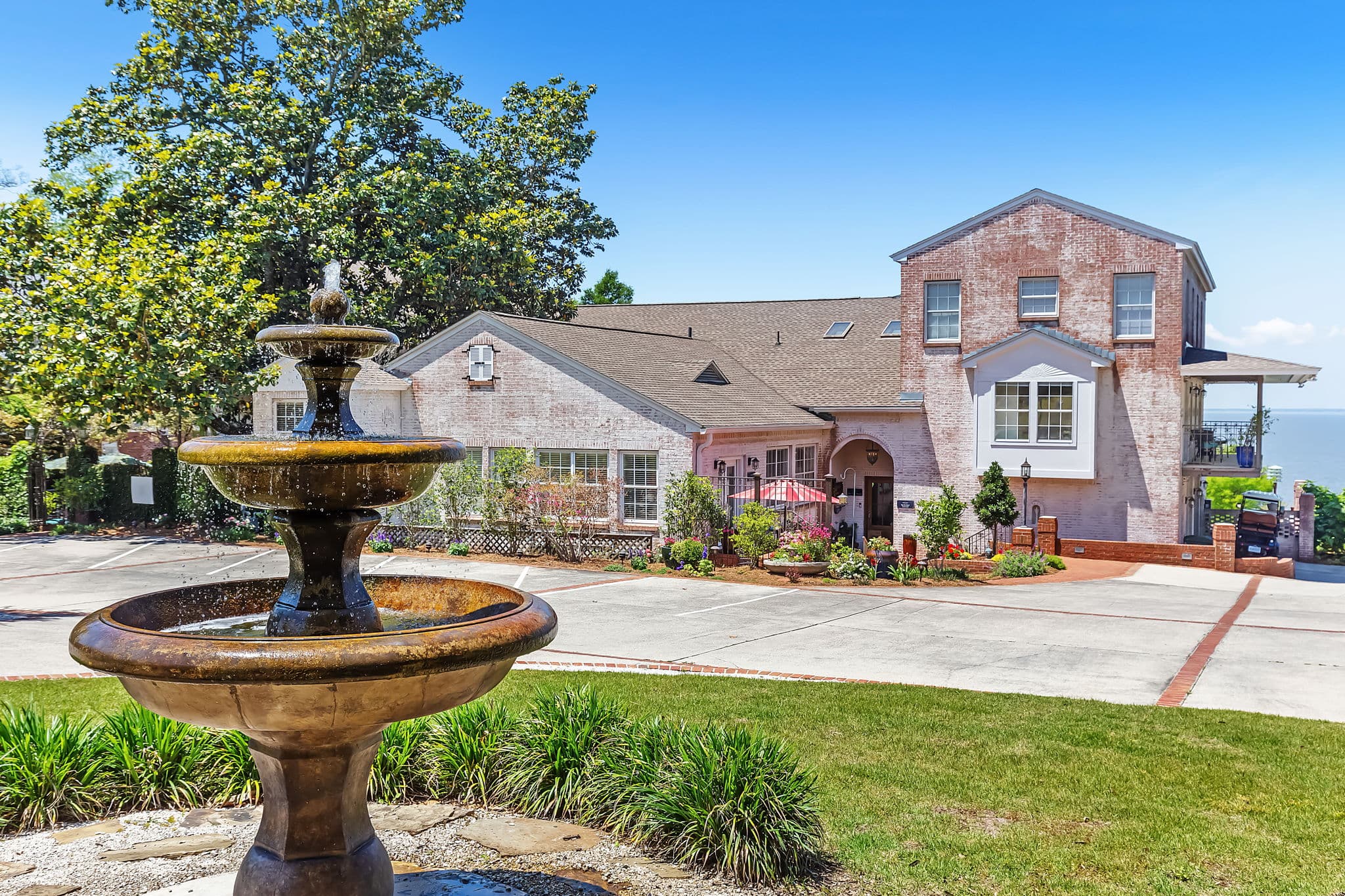Exterior of Jubilee Suites surrounded by lovely landscaping and a three-tiered fountain in the foreground