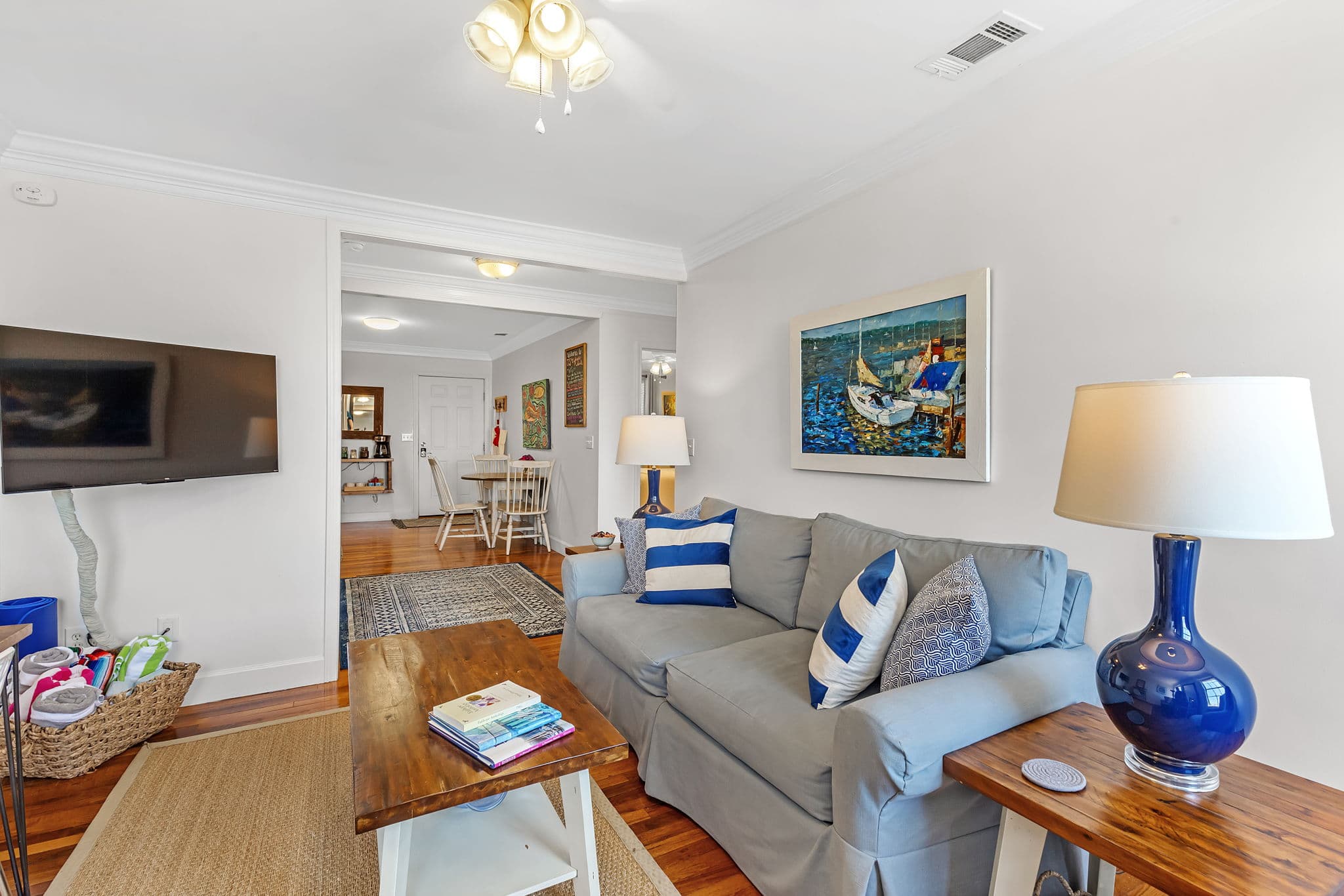 Living Area with couch, coffee table, end tables with lamps, and smart TV with doorway leading to eat-in kitchen