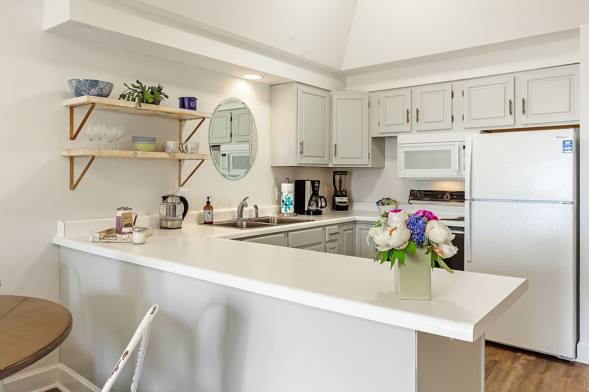 A full kitchen with white cabinets and countertops.