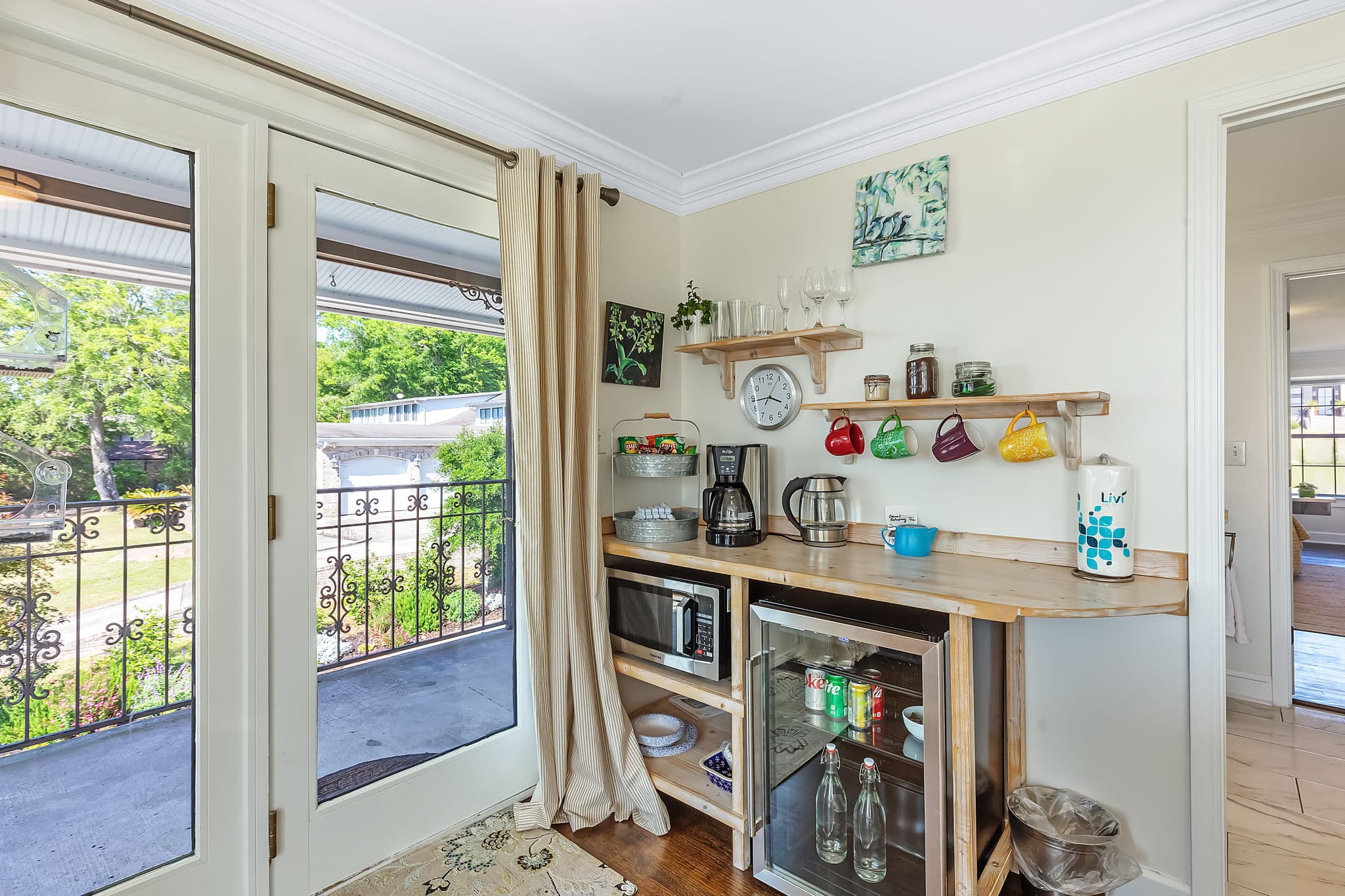 Kitchenette with bar counter, appliances, and balcony view.
