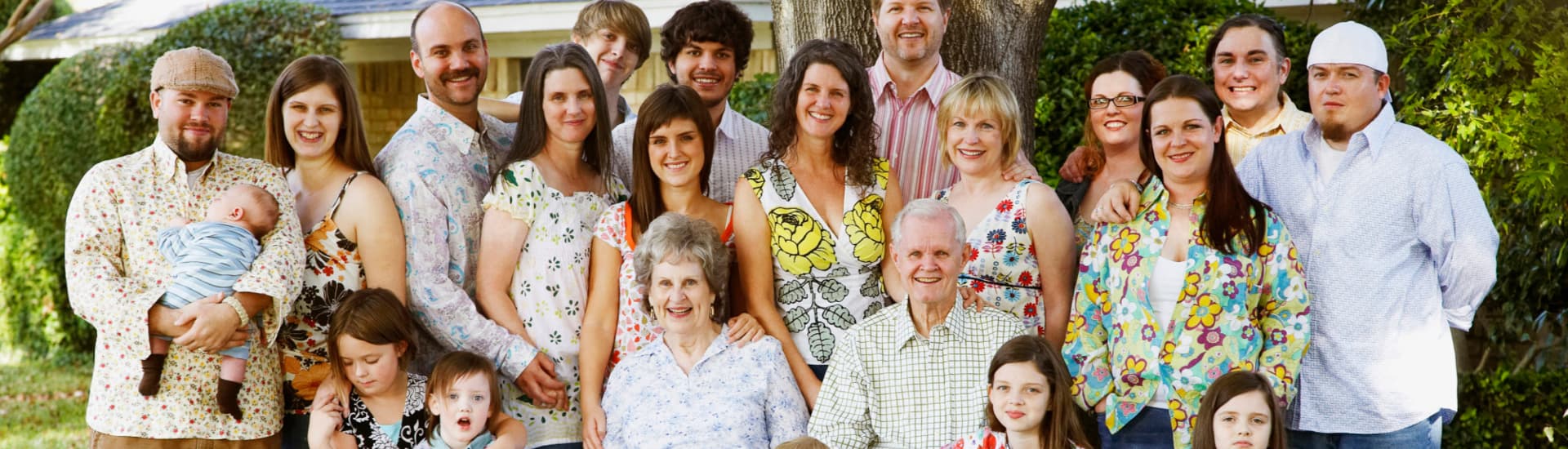 A large family of various ages from babies to grandparents posing for a family reunion picture.