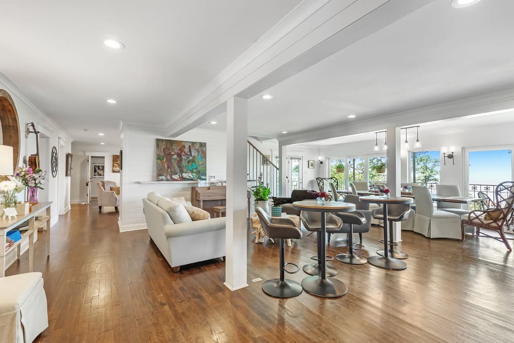 An open social meeting area with recessed lighting and hardwood floors