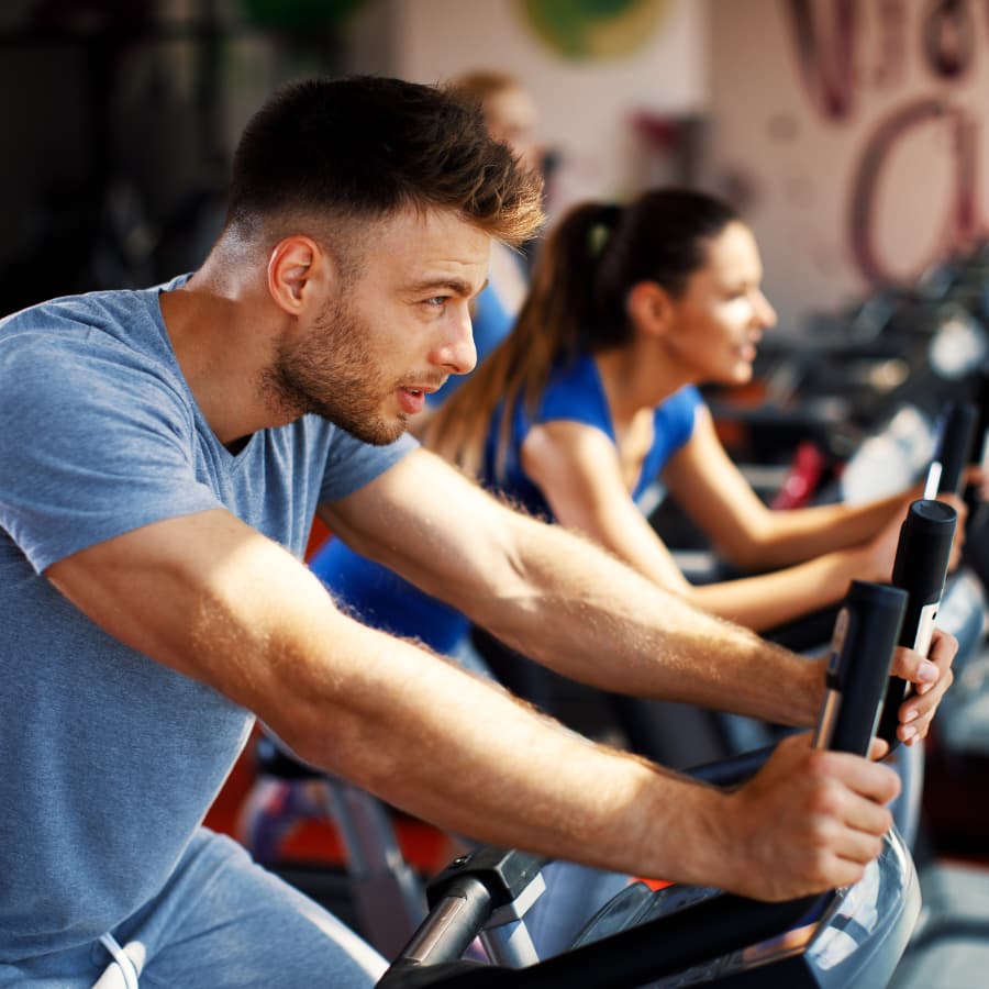 A group of people in a fitness center riding stationary bikes