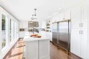 Bright, modern kitchen with white cabinets, stainless steel appliances, and a center island.