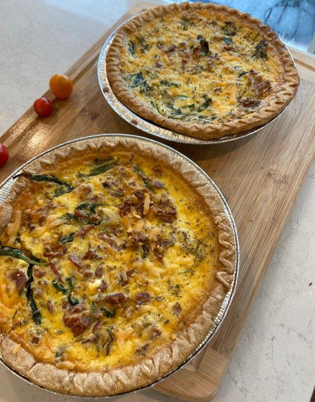 Two baked quiches with a golden crust, filled with spinach, mushrooms, and cheese."