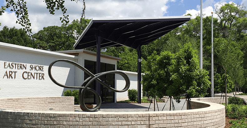 Entrance of the Eastern Shore Art Center featuring a modern canopy and abstract sculpture.