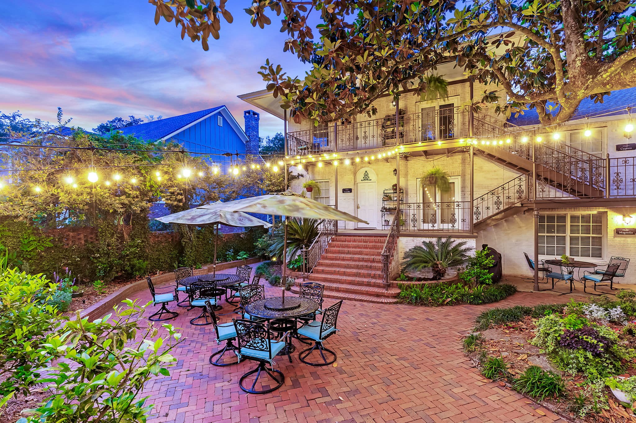 Exterior view of Jubilee Suites at sunset with brick, paved courtyard in foreground